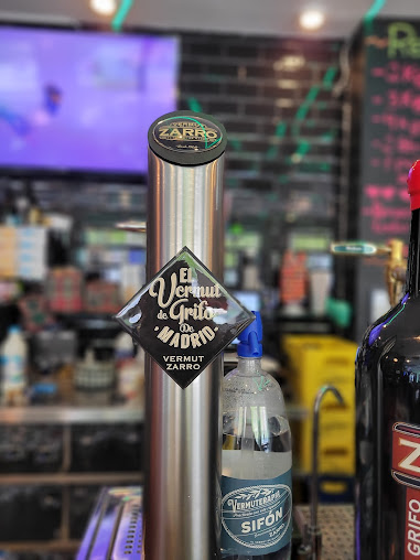 Grifo de vermut en barra de bar, ideal para acompañar tapas originales en Madrid con coins